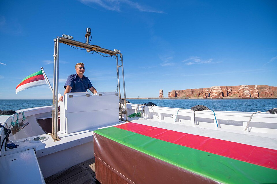 Helgoland: Ein Helgoländer Börteboot passiert das Wahrzeichen der Insel, die Lange Anna